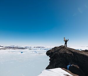 Stay, the guide dog mascot, with expeditioner Bryce Kennedy victorious at the summit of one of the peaks on Ufs Island.