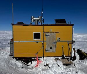 Yellow shed on an icy landscape