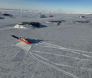 Aerial of large red icebreaker parked up in the ice at Davis