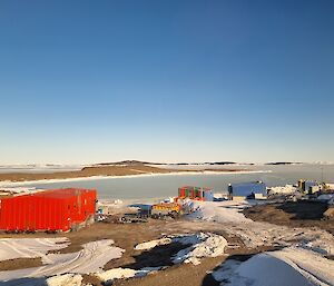 The view from the dog room out towards the west. The red building is the Mechanical, Electrical and Plumbing workshops. The blue building is the Main Power House (MPH). the multi-coloured building in the middle is the Carpentry workshop (Rosella)
