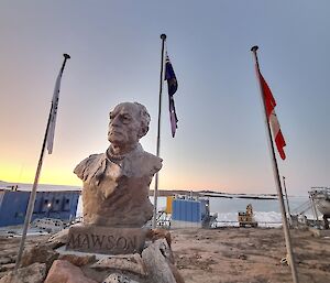 Sunrise and sunset at Mawson flagpoles with the bust of Mawson in the foreground. At this time of year there is no night!