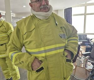 Image of Expeditioner smiling while dressed in fire suit, standing in the Casey 'Wallow' (Lounge area).
