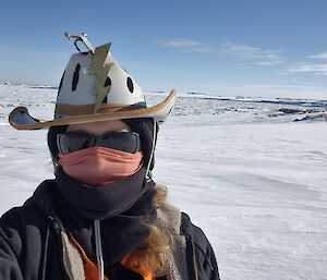 Image of Expeditioner taking selfie. Background is of landscape that features snow, rocks, sea ice, water and the horizon.