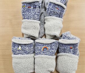 Image of five pairs of issued socks with small icon images sewn into them.