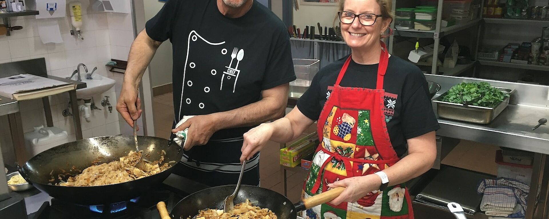 Dr Jan and Chef Kim cooking in woks in the Mawson kitchen