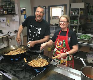 Dr Jan and Chef Kim cooking in woks in the Mawson kitchen