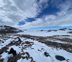 Vast snowy and rocky landscape under a blue sky