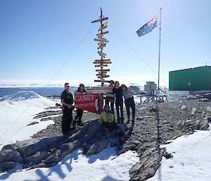 Image of 6 people standing next to the Casey station signpost.