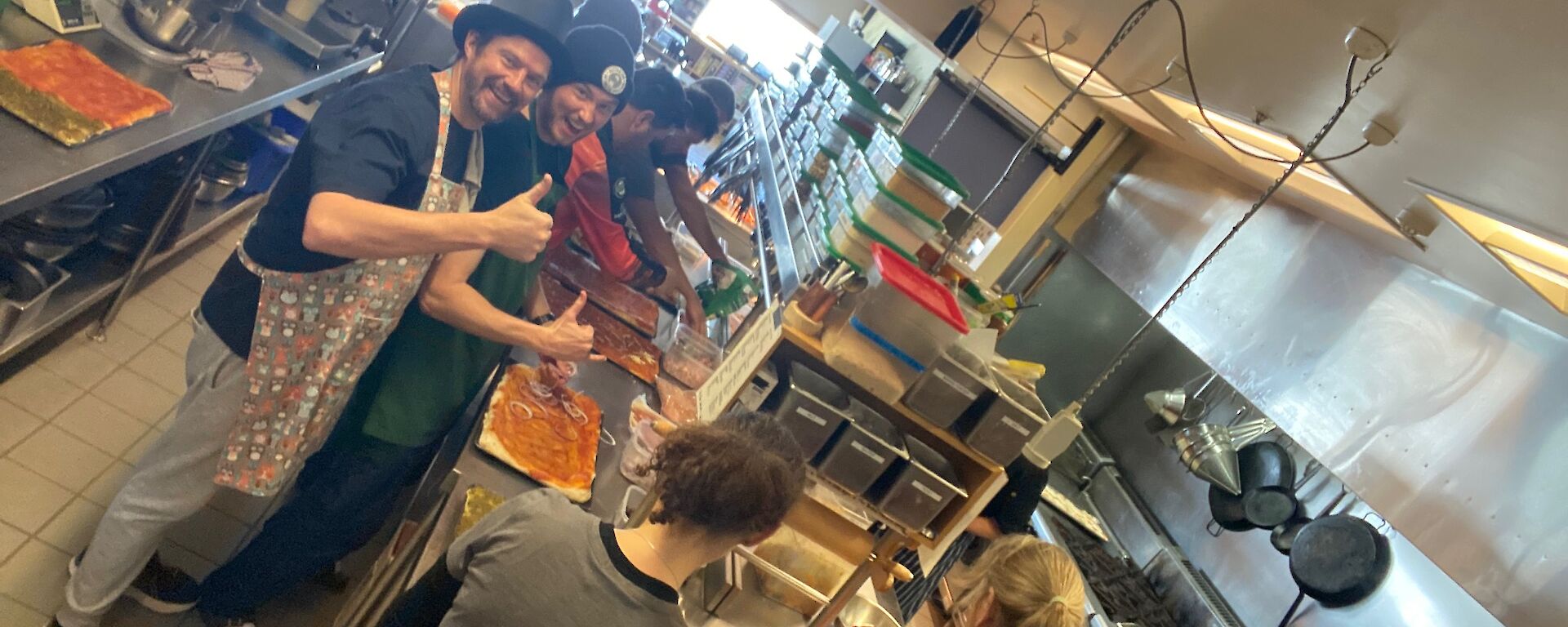 A group of expeditioners standing in a commercial kitchen