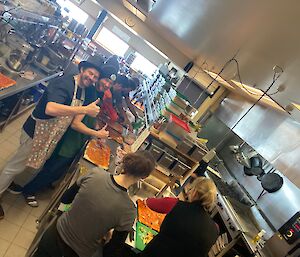 A group of expeditioners standing in a commercial kitchen