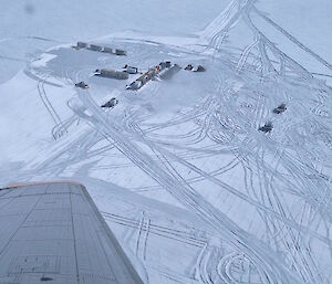 Arial view of the Dome C North site - traverse tractors and tents set up against white ice background