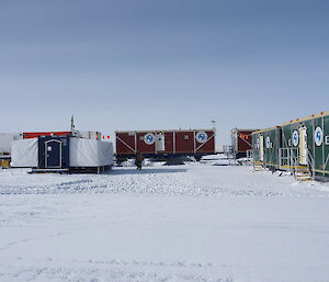 External view of the base camp - red and green rectangular containers with the Australian Antarctic Program logo on the front
