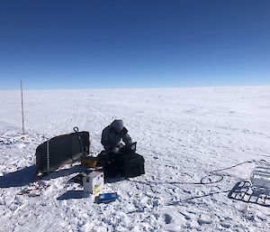 A person working with scientific equipment on the ice in Antarctica.