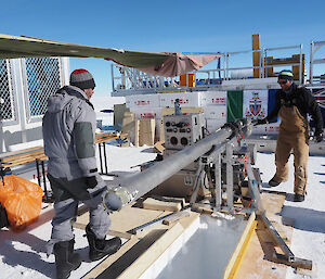 Two people standing near the ice core drill