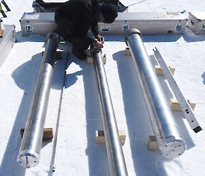 One person prepares ice core equipment on a white field
