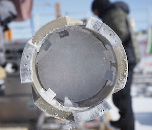 A cylinder of ice inside a metal drill barrel