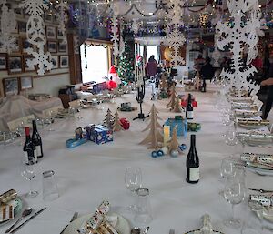 A dining table set for Christmas with decorations and bon bons