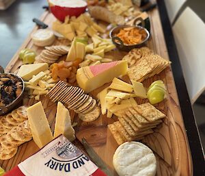 A wooden platter of cheese and biscuits