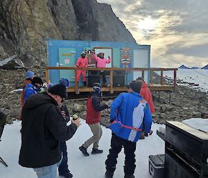 Expeditioners dancing on the snow at Rumdoodle hut