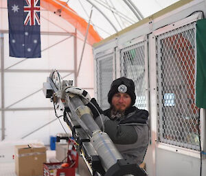 A man holding the end of an ice core drill barrel
