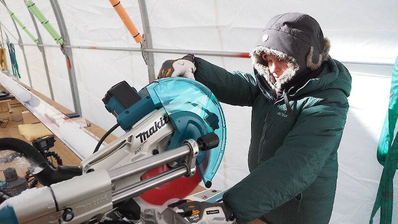 A woman uses a circular saw to cut an ice core