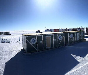 Shipping containers and semi-circular tents on a flat area of ice