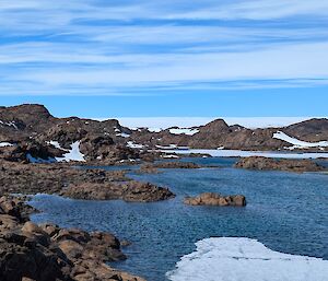 A lake surrounded by brown rocks