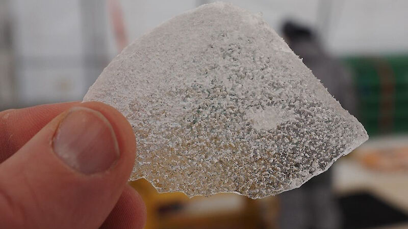 A chip of ice containing air bubbles.