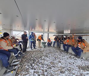 A group of tradies sitting under a white ceiling having a break