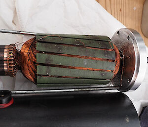 A motor from an ice core drill with lots of thin copper filaments inside a metal casing