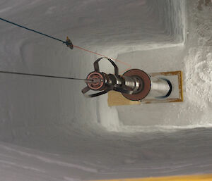 A cylindrical instrument enters a hole at the bottom of an ice trench