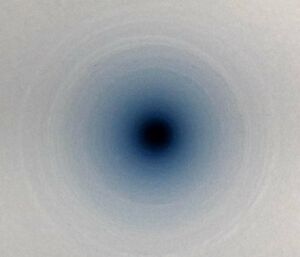 Looking down into a hole in blue ice