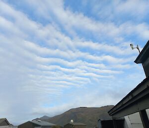Stripey clouds above a mountain and station buildings