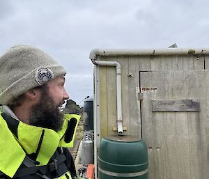 Side on view of a man looking at a hut