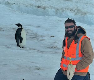 Image of expeditioner and an Emperor penguin