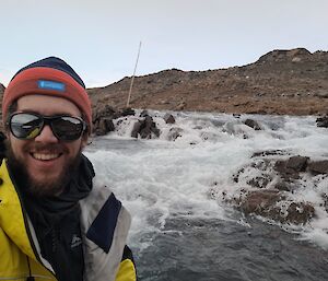 Close-up of an expeditioner with water flowing in the background