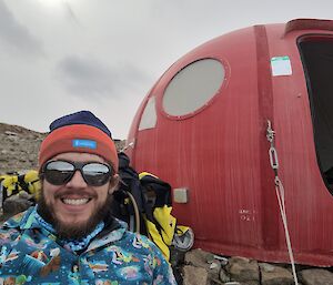 Close-of up of an expeditioner in front of a Melon hut