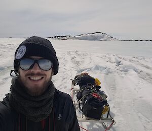 Close-up of an expeditioner with a sled in the background
