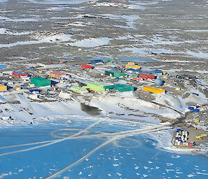 Aerial view of colourful buildings set amongst snow-covered rocks