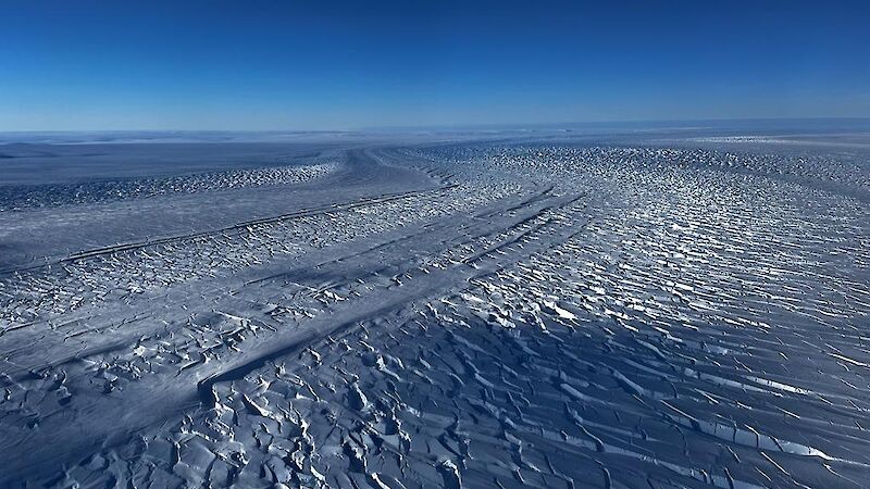 A river of ice stretching out as far as the eye can see, under a cloudless blue sky