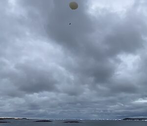 A large, white balloon, high in the sky.