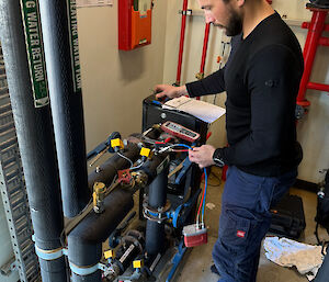 A man in thermals inspects some pipes