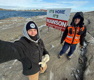 A man takes a selfie near the It's Mawson, It's Home sign.