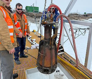 An elongated copper bell being placed into ice