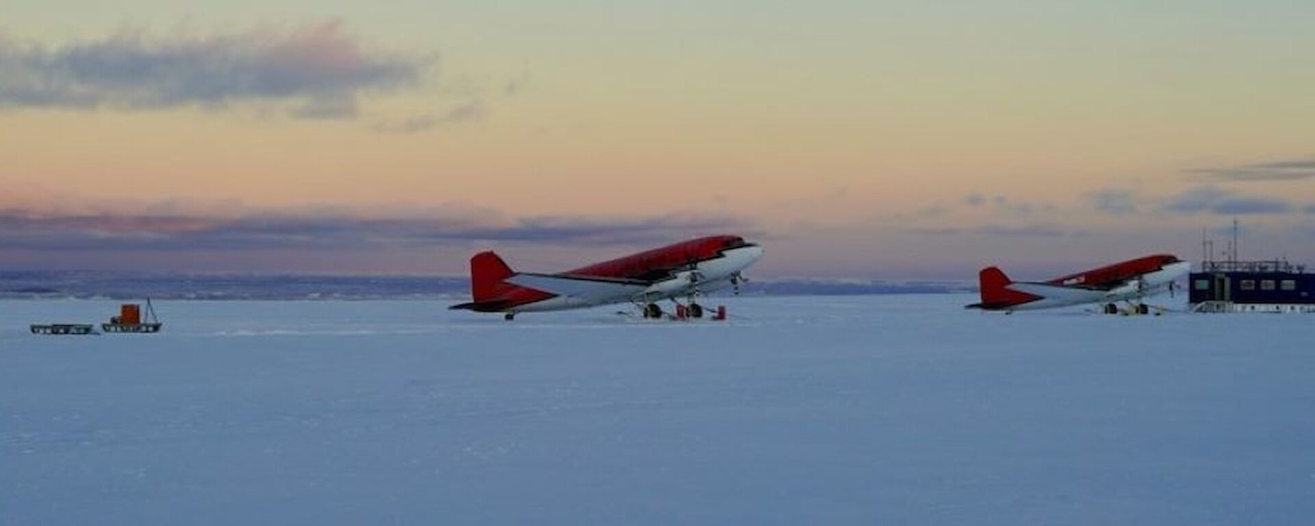 Image of two DC3 Baselr Aircraft and one twin Otter Aircraft at the Casey Skiway at sunrise.