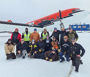 Image of 16 people posing in front of Basler aircraft.