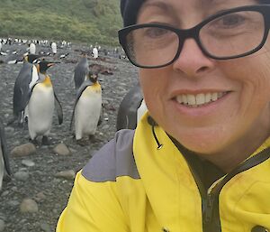 Selfie of woman with king penguins over shoulder