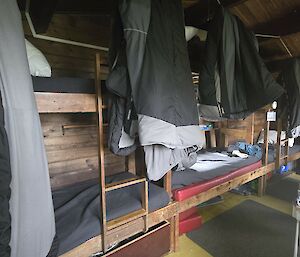 Row of bunk beds along back wall of the hut