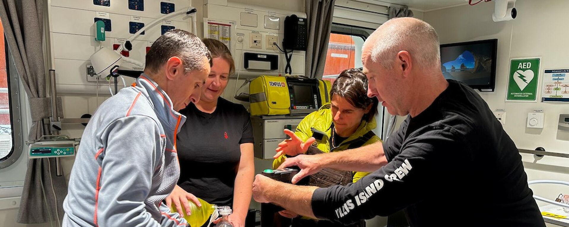 A group of people perform a mock operation on a dummy