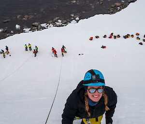 Image of expeditioner climbing up an ice scructure.